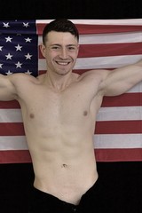 Male fitness model wrapped in the American flag on the 4th of July