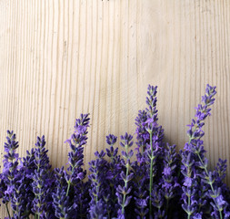 Naklejka premium Lavender flowers on old wooden background. Place for text. Natural background.