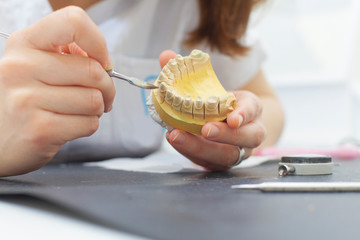 dental technician shaping a prosthesis tooth