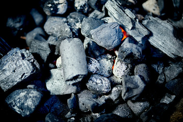 Closeup of glowing coal in metal grill on summer day in garden