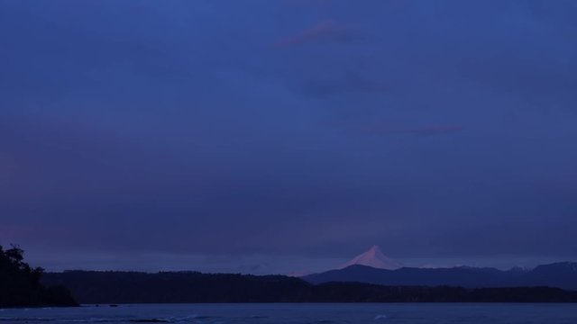Time lapse on the shore of Lake Llanquihue in the village of Puerto Octay at sunset overlooking Puntiagudo volcano