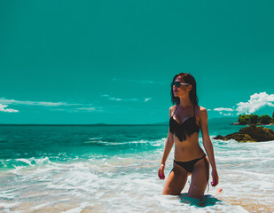 Young beautiful girl in pink bikini on on a beach