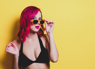 Young pink hair girl in bikini and orange glasses