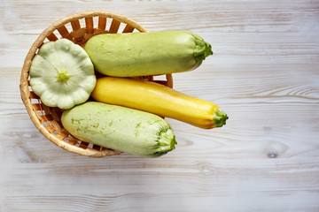 Fresh organic summer vegetables zucchini on rustic wooden background. Top view, space for text.
