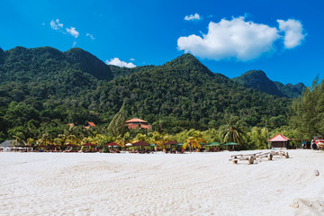 Fototapeta na wymiar Relaxing on remote paradise beach. Tropical bungalow and luxury house on untouched sandy beach with palms trees in Langkawi Island, Malaysia.