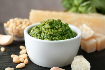 Bowl of pesto sauce and ingredients on table