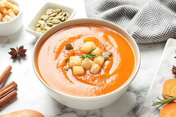 Bowl of tasty sweet potato soup served on table