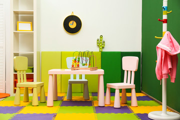 Stylish playroom interior with table and chairs