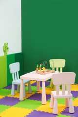 Stylish playroom interior with table and chairs. Space for text