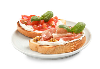 Plate with tasty bruschettas on white background