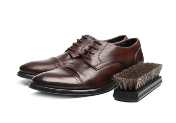 Stylish men's shoes and cleaning brush on white background