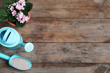 Flat lay composition with gardening tools and chemical fertilizer on wooden table. Space for text