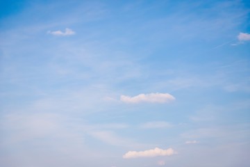 Small clouds on a light blue sky background, soft color