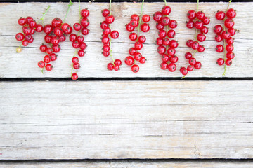 Healthy red currants on a wooden background in the garden, summer concept