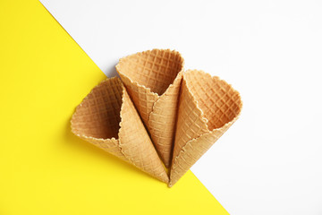 Waffle empty ice cream cones on color background, flat lay