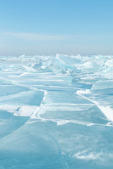 Fototapeta na wymiar transparent blue cracked ice surface of Lake Baikal in winter