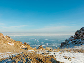 Landscape of frozen Lake Baikal in winter with background of hills and blue sky from view point cape at Olkhon island.