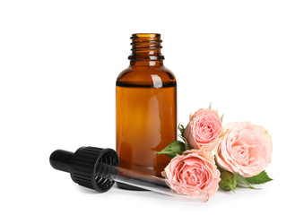 Bottle of rose essential oil and flowers isolated on white