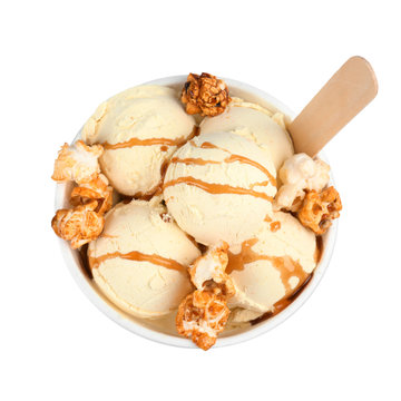 Delicious ice cream with caramel popcorn and sauce in dessert bowl on white background, top view