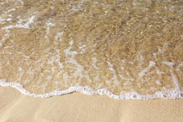 View of sea water and beach sand on sunny day