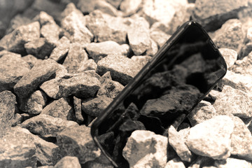 Broken cellphone abandoned and lost among the gravel