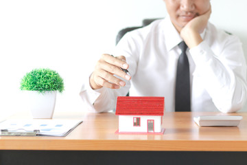 Business young man holding house, Real estate investment is a business to build a house to sell to buyers in the market through agents. estate service concept