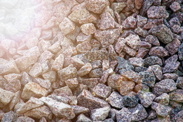 Road gravel and granite gravel texture. Crushed Gravel background. Pile of Stones texture with sunbeam lights. Industrial coals