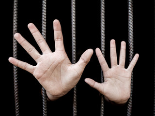 Human in prison showing stop hand, Young man desperate to catch the iron prison,prisoner concept,