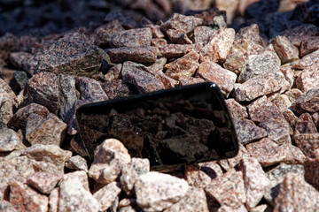 Broken cellphone abandoned and lost among the gravel
