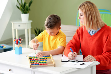 Female psychologist working with boy suffering from autistic disorder