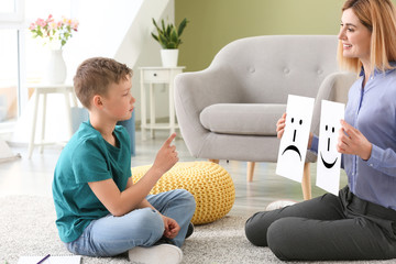 Female psychologist working with boy suffering from autistic disorder