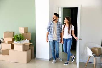 Young couple with belongings in their new house