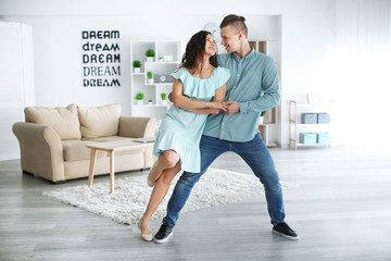 Adorable loving couple dancing at home