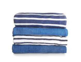 Stack of modern clothes on white background