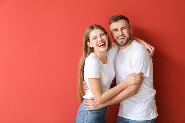 Portrait of happy young couple on color background