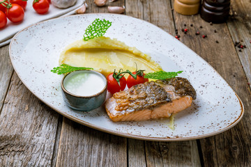Salmon steak on the grill on wooden background
