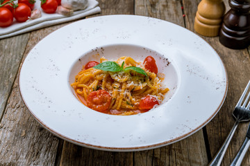 Pomodoro spaghetti in white plate on wooden background