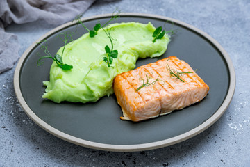 Salmon steak on the grill with green mashed beens