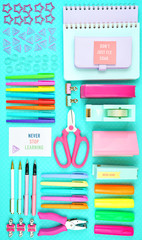 Back to school or workspace colorful stationery on aqua blue background, overhead flat lay.