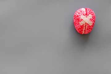 Mental health concept with brain with patches on gray background top view space for text
