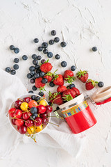 fresh berries of cherry, strawberry and blueberry dropped on the table