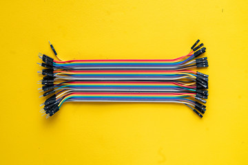 bunch of electronic wires or caples in colorful isolation on the table, connection concept