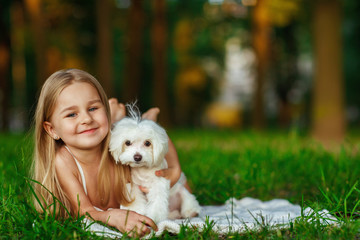 Children with a maltese puppy, outdoor summer