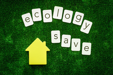 Ecology save text and house for eco friendly concept on green texture background top view
