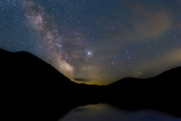 smoke from wildfire and milky way reflecting over a lake in washington usa