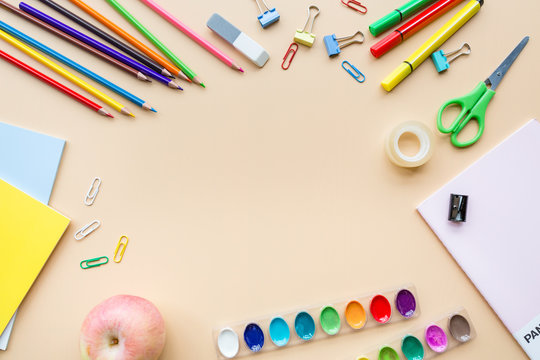 School supplies stationery, colour pencils, paints, paper on pastel orange background, back to school concept with free copy space for text, modern elementary education. flat lay, top view, mockup.