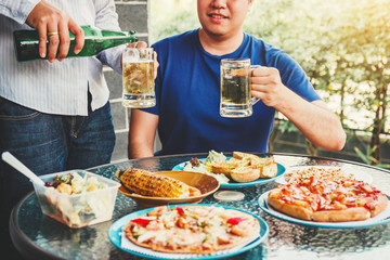 Afternoon Party Group friends enjoying drinking beer with barbecue and roast pork happy while enjoying home party