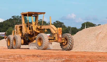 Motor Grader bulldozer heavy equipment at a construction site. - obrazy, fototapety, plakaty