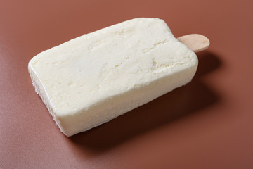 side view fresh milkshake flavor popsicle on a brown background