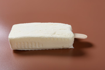 side view fresh milkshake flavor popsicle on a brown background with copy space
